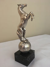Beautifully cast silver plated rearing horse atop a silver plated globe.