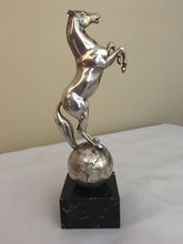 Beautifully cast silver plated rearing horse atop a silver plated globe.