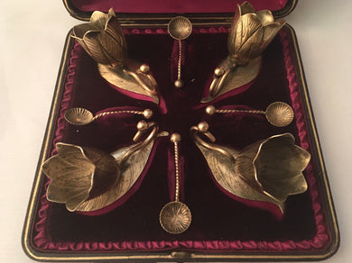 Victorian cased set of four novelty gilt metal salts and spoons, in the form of flowers and leaves.