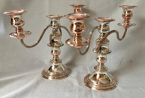Early 20th century pair of silver plate on copper twin branch three light candelabra, converting to candlesticks.