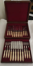 George V, walnut cased 12 person canteen of cutlery with carved ivory handles and silver ferrules. Sheffield 1923 William Hutton & Sons